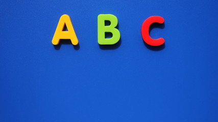 ABC first letter of the English alphabet on a blue background. Empty space for text. Learning foreign language.