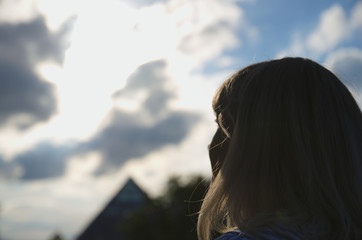 Woman look at cloudy sky, cumulus clouds lights in sun rays, pyramid at horizon