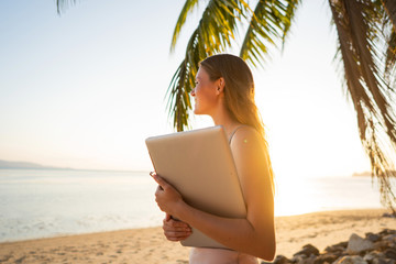 freelancer girl among tropical palm trees work on the island
