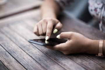 Close up of hands woman using her cell phone. Outdoor.