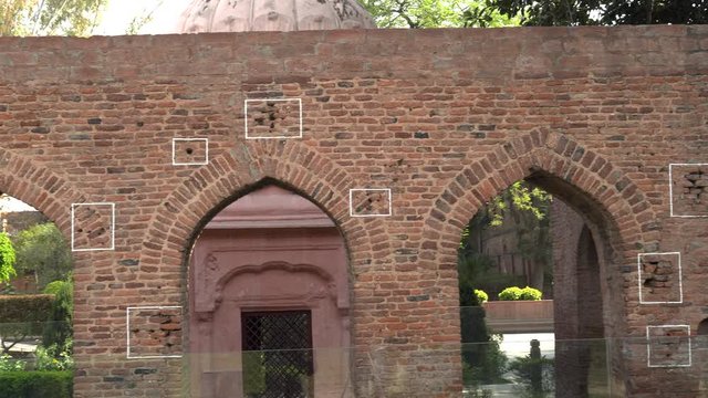 pan left of bullet holes in a wall at jallianwala bagh memorial in amritsar, india