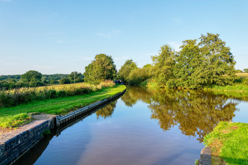 Fototapeta na wymiar Late summer afternoon on the still waters of the Shropshire Union Canal near Whitchurch.