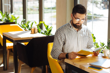 Good looking young man being focused on the book