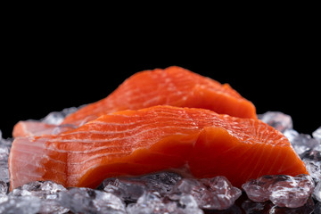 Uncooked salmon filet in ice on dark  background. Raw salmon fillet. Copy space