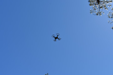 Drone on flight under a clear blue sky.