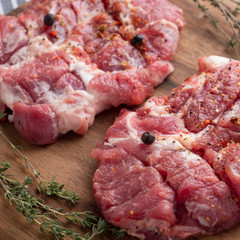 Raw pork neck pieces with spices. Closeup. Macro view