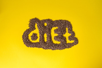 The phrase "Diet" is laid out from buckwheat on a yellow background. Proper and healthy nutrition and products