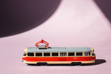 Model of a Russian tram on a pink background with sunlight. Russian transport. Toy model