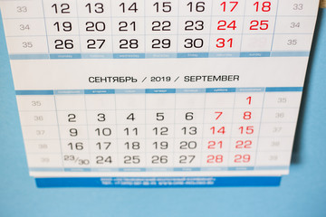 Close-up calendar for the month of September 2019. Hello September. Hello, Autumn. Russian-English calendar on a blue background