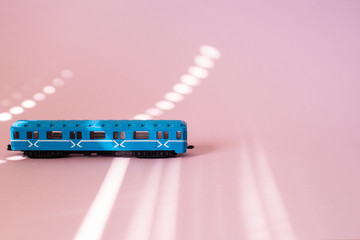 Model of a Russian metro car on a pink background with sunlight. Russian transport. Toy model