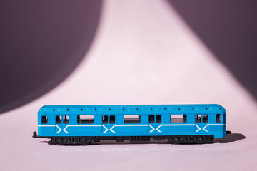 Model of a Russian metro car on a pink background with sunlight. Russian transport. Toy model