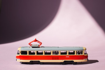 Model of a Russian tram on a pink background with sunlight. Russian transport. Toy model