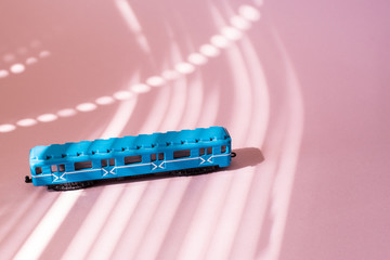 Model of a Russian metro car on a pink background with sunlight. Russian transport. Toy model
