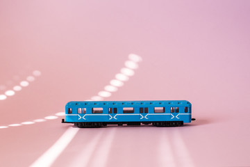 Model of a Russian metro car on a pink background with sunlight. Russian transport. Toy model