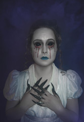 Pale skin woman in gothic style with bloody tears. Halloween scene