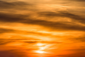 Huge sun behind stormy dramatic sky. background with yellow red and orange clouds. Sunset skyline. Storm on the beach