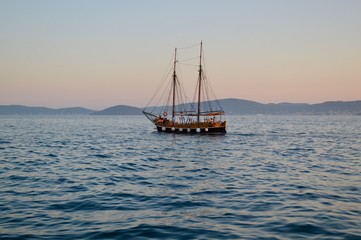 Fototapeta na wymiar Barca a vela in mare al tramonto