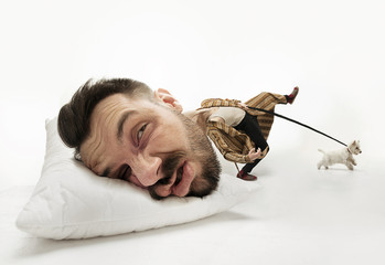 Let me sleep 5 minutes more. Big head on small body lying on the pillow. Man can't wake up and walk the dog 'cause has headache and overslept. Concept of business, working, hurrying up, time limits.