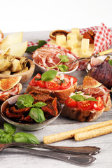 Italian antipasti wine snacks set. Cheese variety, Mediterranean olives, Prosciutto di Parma, tomatoes, artichokes