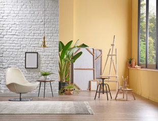 White brick wall and yellow background interior style, lamp frame chair and easel decor, home decoration interior.