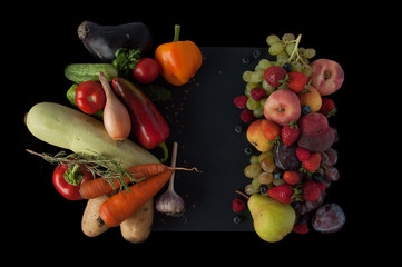 A lot of natural and healthy vitamin fruits, berries and vegetables natural products on a black background. Vegan eco safe food. Proper weight loss food.