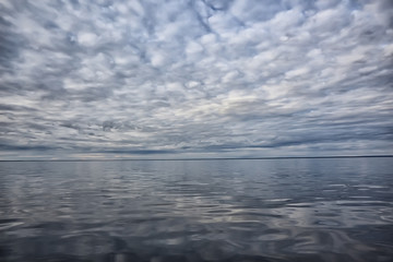 sky above water / texture background, horizon sky with clouds on the lake