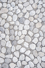 Full frame background of smooth white stones with rounded edges in gray mortar