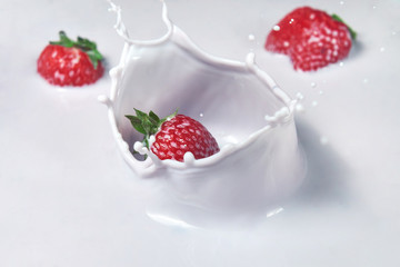 Healthy food, delicious dessert - strawberries falling in a milk fruit cream. Splash slow motion.