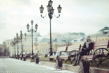 woman on a bench in a winter city
