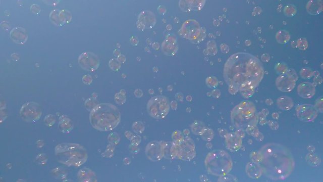 soap bubbles on blue sky background, beautiful sunlight on summer day during a children's holiday on weekend, concept of happiness and bubble blower