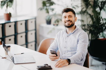 Portrait of young businessman use on mobile phone in office