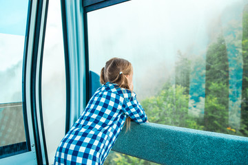 Adorable little girl in the cabin on the cable car in mountains © travnikovstudio