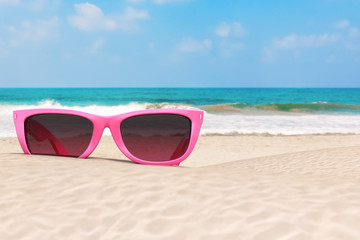 Summer Vacation Concept. Blue Skies with Modern Pink Sunglasses on an Ocean Deserted Coast. 3d Rendering