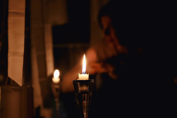 Christmas evening girl / beautiful young adult model, dreams and makes wishes at the candles in the New Year's Eve