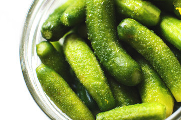jar with pickled cucumbers on a white background. gherkins cucumbers top view