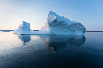 Photogenic and intricate iceberg under an interesting and blue sky during sunset. Effect of global...
