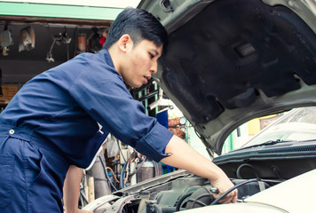 A man is fixing machine in automotive service center