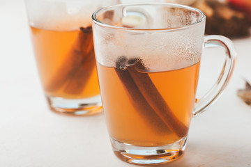 Autumn hot spicy tea glasses with cinnamon sticks