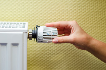 Close Up Of Hand Adjusting Heating Thermostat.