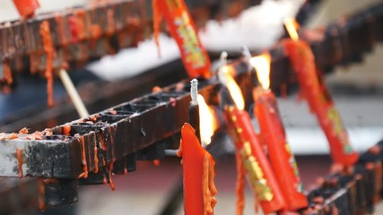 Video 4k of flame from burning red chinese candle in the temple