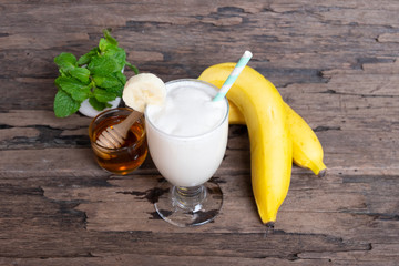 Banana fresh cocktail vanilla smoothies juice white fruit beverage healthy the taste yummy In glass for milkshake on wooden background.