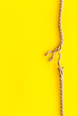 risk concept with rope near to break on yellow background top view space for text