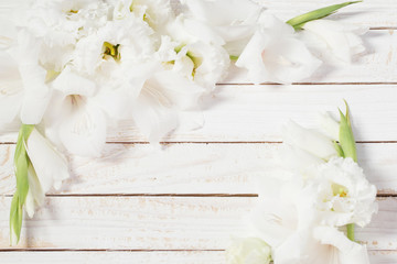 white gladiolus and eustoma on white wooden background
