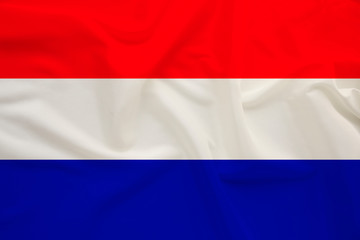 national flag of the country Holland on gentle silk with wind folds, travel concept, immigration, politics, copy space, close-up