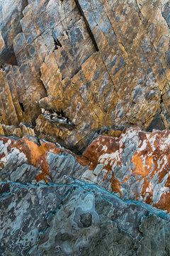 Abstract rock pattern as sawtooth in orange and gray tones at beach in Bay of Biscay, Spain