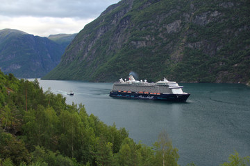beautiful white water liner sailing through a narrow fjord in Norway