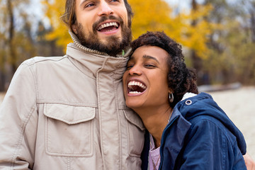 guy with an african american girl in love in autumn park makes her an offer to get married