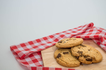 homemade chocolate chip cookies with red white napkin and white background