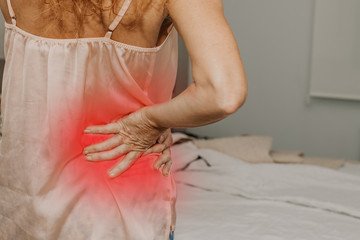 adult woman in the bedroom with symptoms of muscle pain