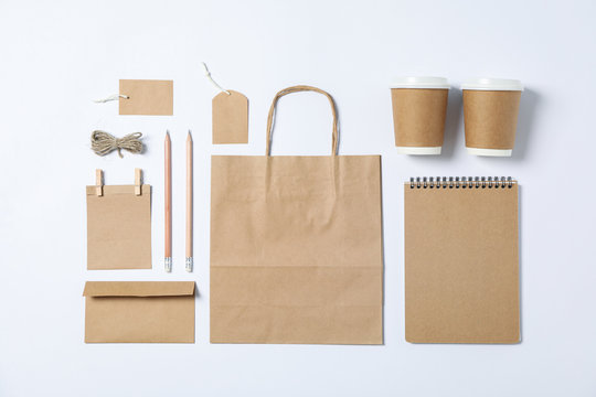 Flat lay composition with blank stationery, paper cups and bag on white background, mockup